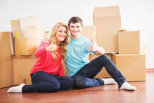 Professional movers handling boxes and furniture in a Watford apartment